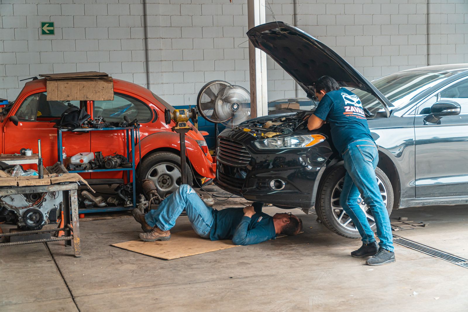 Technicians working on a vehicle in a service bay.